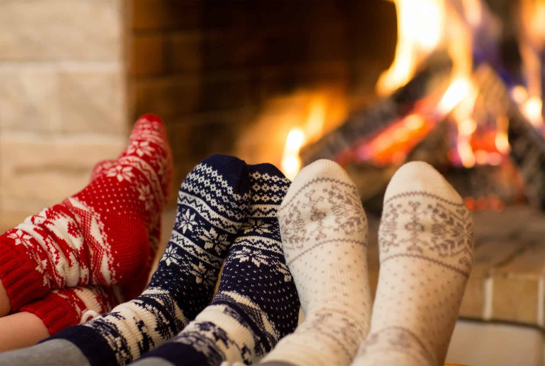 Feet in wool socks near fireplace in winter time