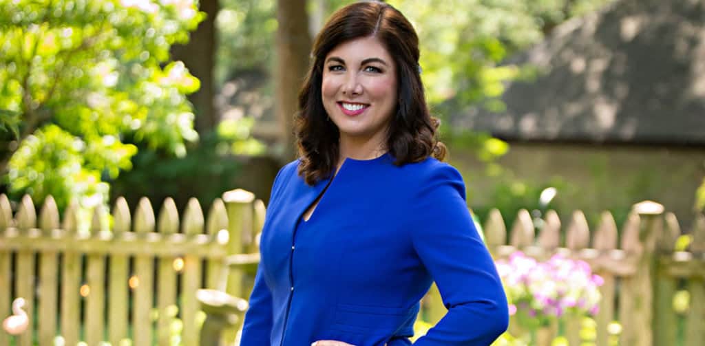 Joyce Marter standing in a garden in a blue dress