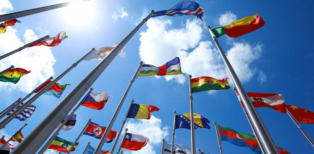 flags of different countries flying in the clouds