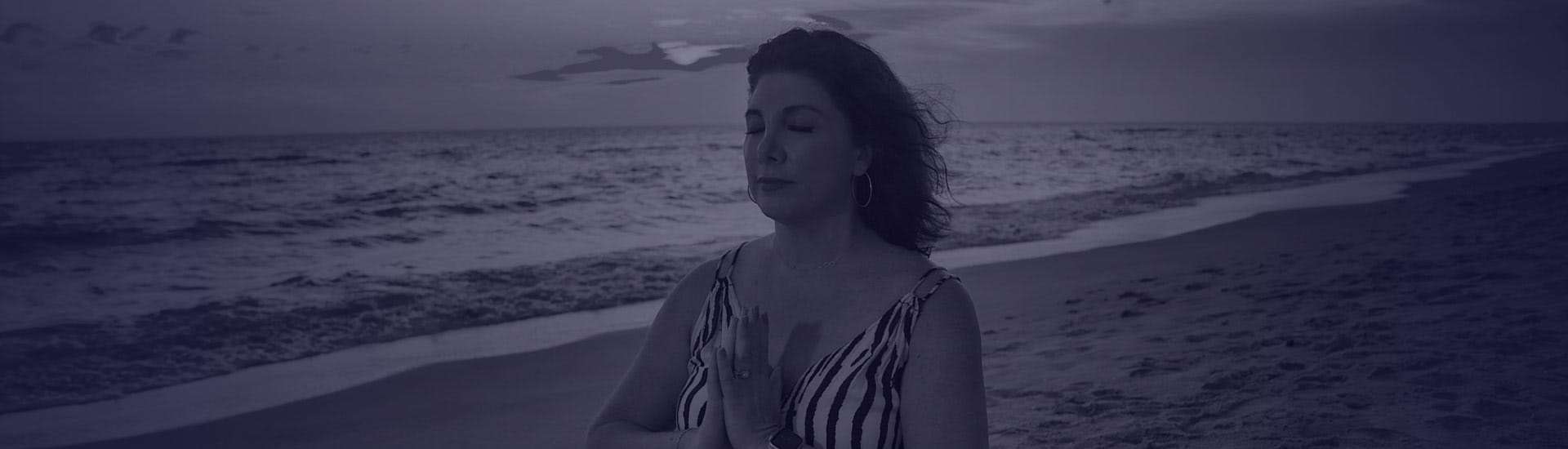 Joyce standing at a beach breathing in air practicing mindfulness