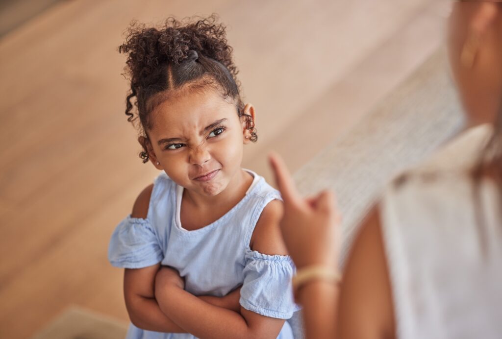 Angry child and tantrum discipline conflict for attitude problem in home with stressed mother. Young girl frustrated, unhappy and moody at disappointed adult punishment for negative behaviour.